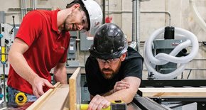 Guys wearing hard harts working in shop